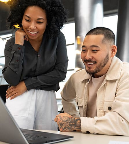 Diverse business partners reviewing strategy on a laptop